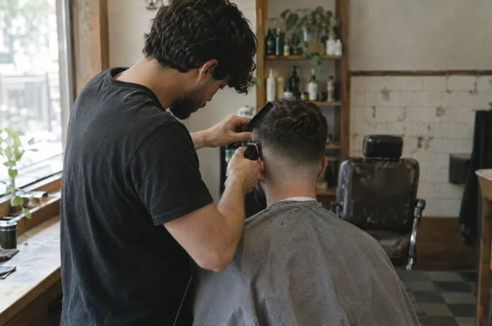 A barber giving a customer a skin fade.